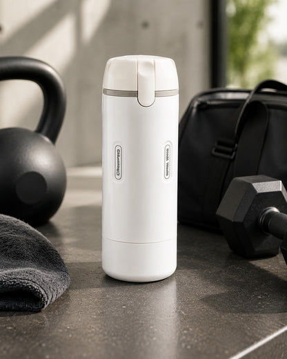 La botella blanca sobre una mesada gris, junto a una pesa rusa, una mancuerna y un bolso de gimnasio
